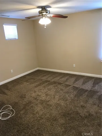 an empty room with a chandelier fan