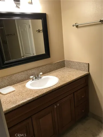 a bathroom with a granite countertop sink and a mirror