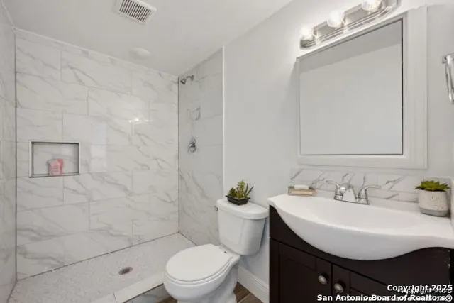 a bathroom with a sink toilet and shower