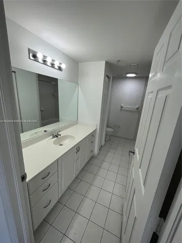 a view of a kitchen with white cabinets and a sink