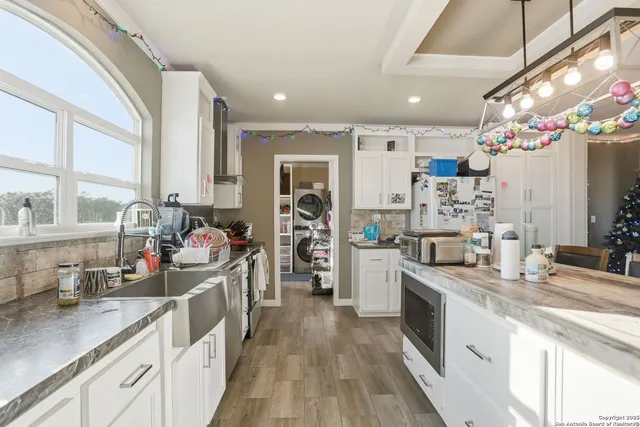 a kitchen that has a lot of cabinets a sink and appliances in it