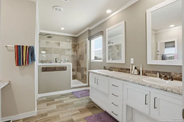 a spacious bathroom with a granite countertop sink and a mirror