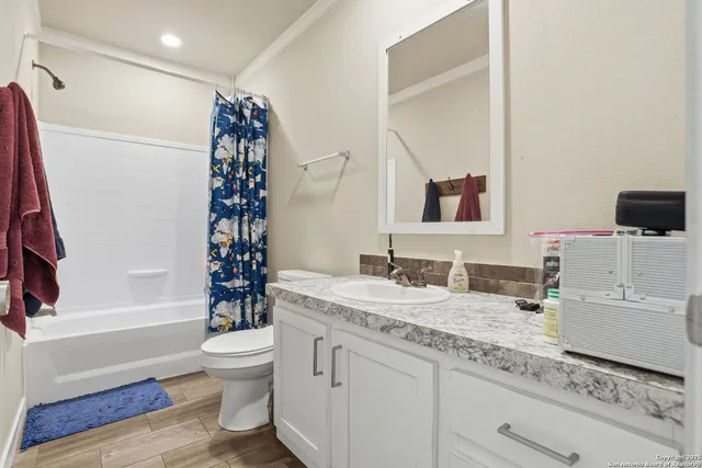 a bathroom with a granite countertop toilet sink and mirror