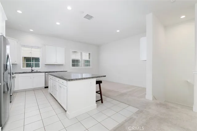 a large white kitchen with a sink and cabinets