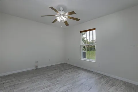 an empty room with a window and chandelier