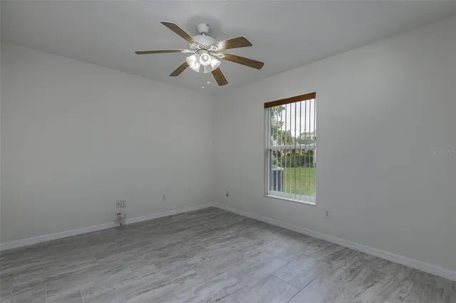 an empty room with a window and chandelier