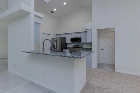 a kitchen with stainless steel appliances granite countertop a refrigerator stove and sink