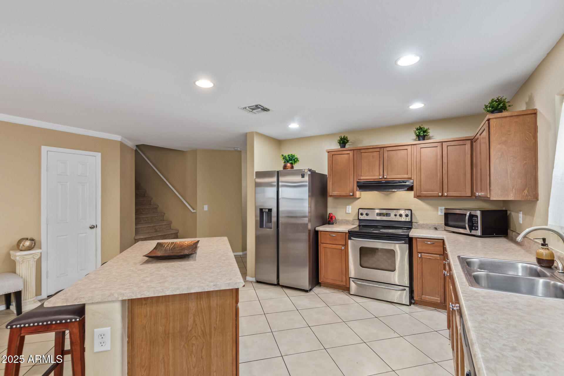 3209 West Apollo Road Phoenix, AZ 85041 - Photo 14 of 40 a kitchen with stainless steel appliances granite countertop a sink stove and refrigerator