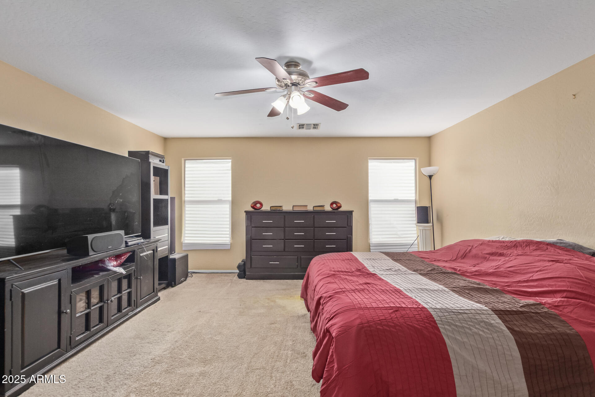 3209 West Apollo Road Phoenix, AZ 85041 - Photo 20 of 40 a spacious bedroom with a bed and a flat screen tv