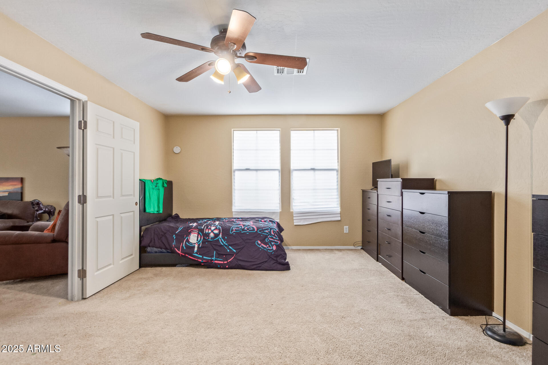 3209 West Apollo Road Phoenix, AZ 85041 - Photo 36 of 40 a spacious bedroom with a bed and a chandelier