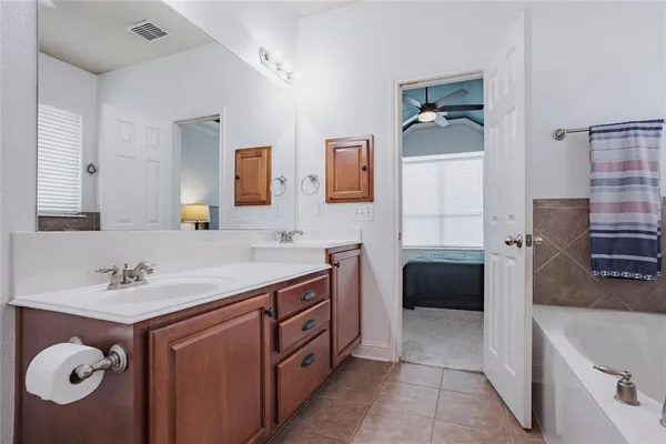 a bathroom with a tub sink and mirror