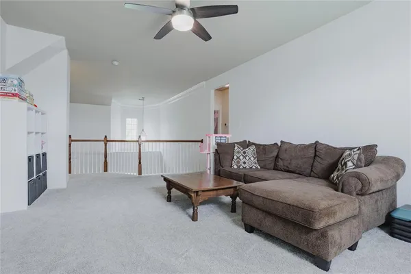 a living room with furniture and a ceiling fan