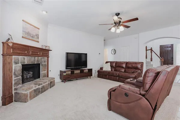 a living room with furniture a flat screen tv and a fireplace