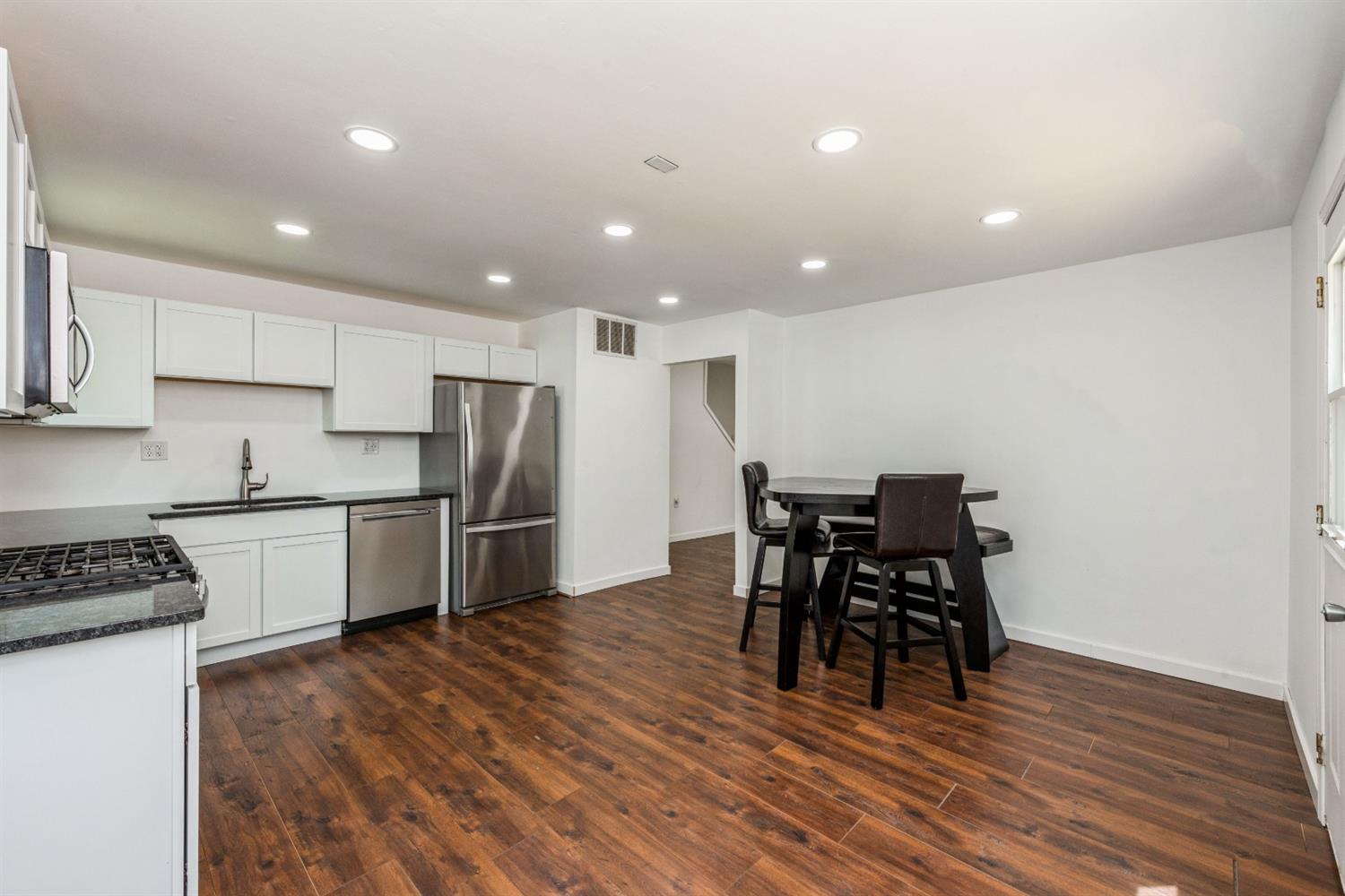 710 Heritage Road Valparaiso, IN 46385 - Photo 6 of 27 a kitchen with stainless steel appliances granite countertop a stove a refrigerator a sink a dining table and chairs with wooden floor