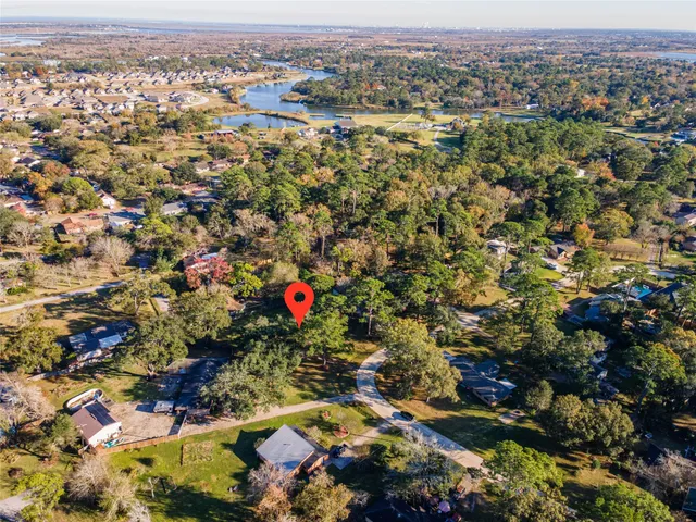 an aerial view of residential houses with outdoor space and trees