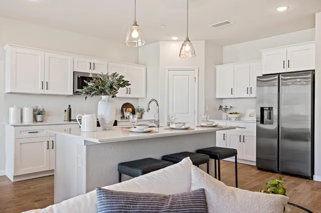 a kitchen with stainless steel appliances granite countertop a sink a stove a refrigerator and island