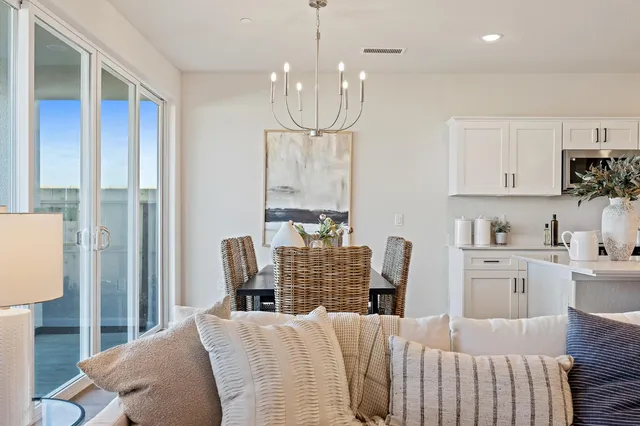 a view of a dining room with furniture a chandelier and wooden floor