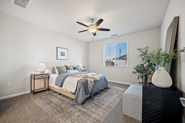 a spacious bedroom with a bed and a potted plant