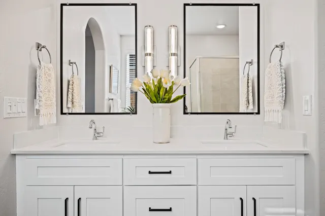 a bathroom with double vanity sinks and a mirror