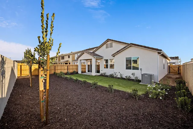 a view of a white house with a yard and potted plants
