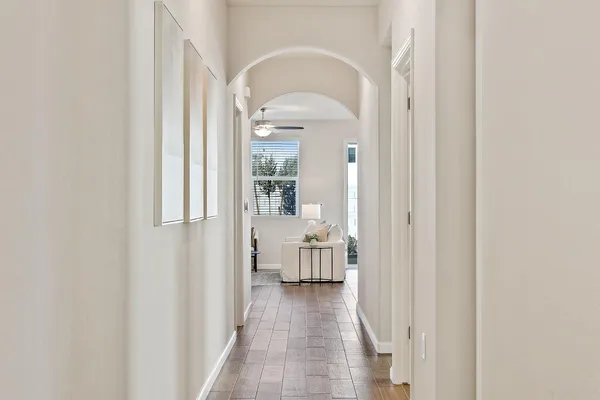 a view of a hallway with wooden floor and living room