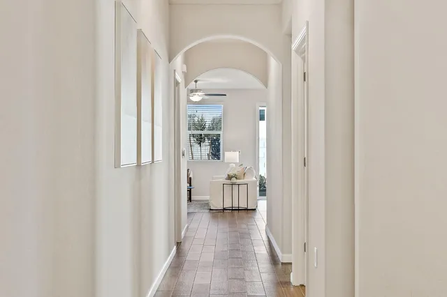 a view of a hallway with wooden floor and living room
