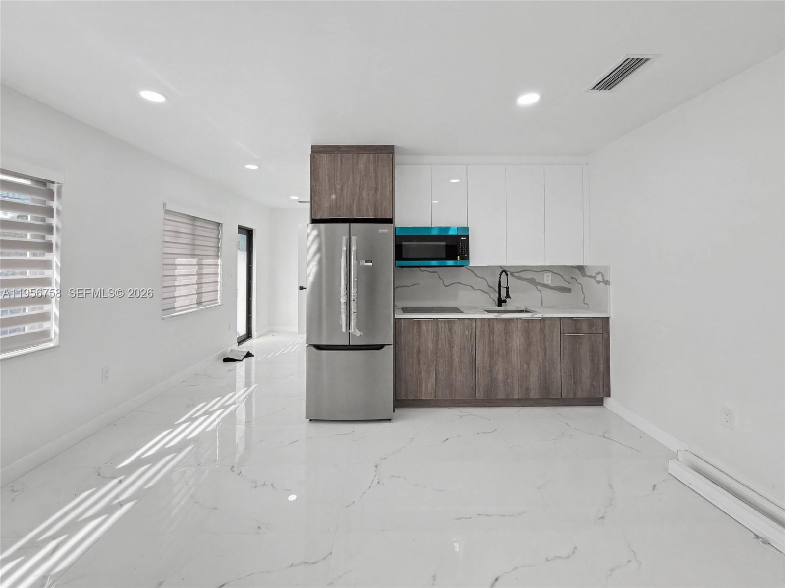 2490 Southwest 17th Street Miami, FL 33145 - Photo 11 of 36 a kitchen with stainless steel appliances a refrigerator sink and cabinets