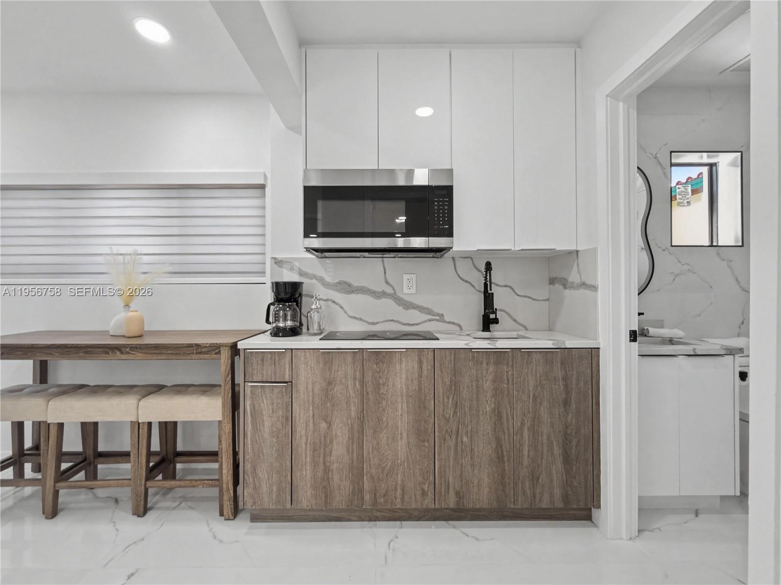 2490 Southwest 17th Street Miami, FL 33145 - Photo 25 of 36 a kitchen with stainless steel appliances a sink a stove a microwave a refrigerator and cabinets