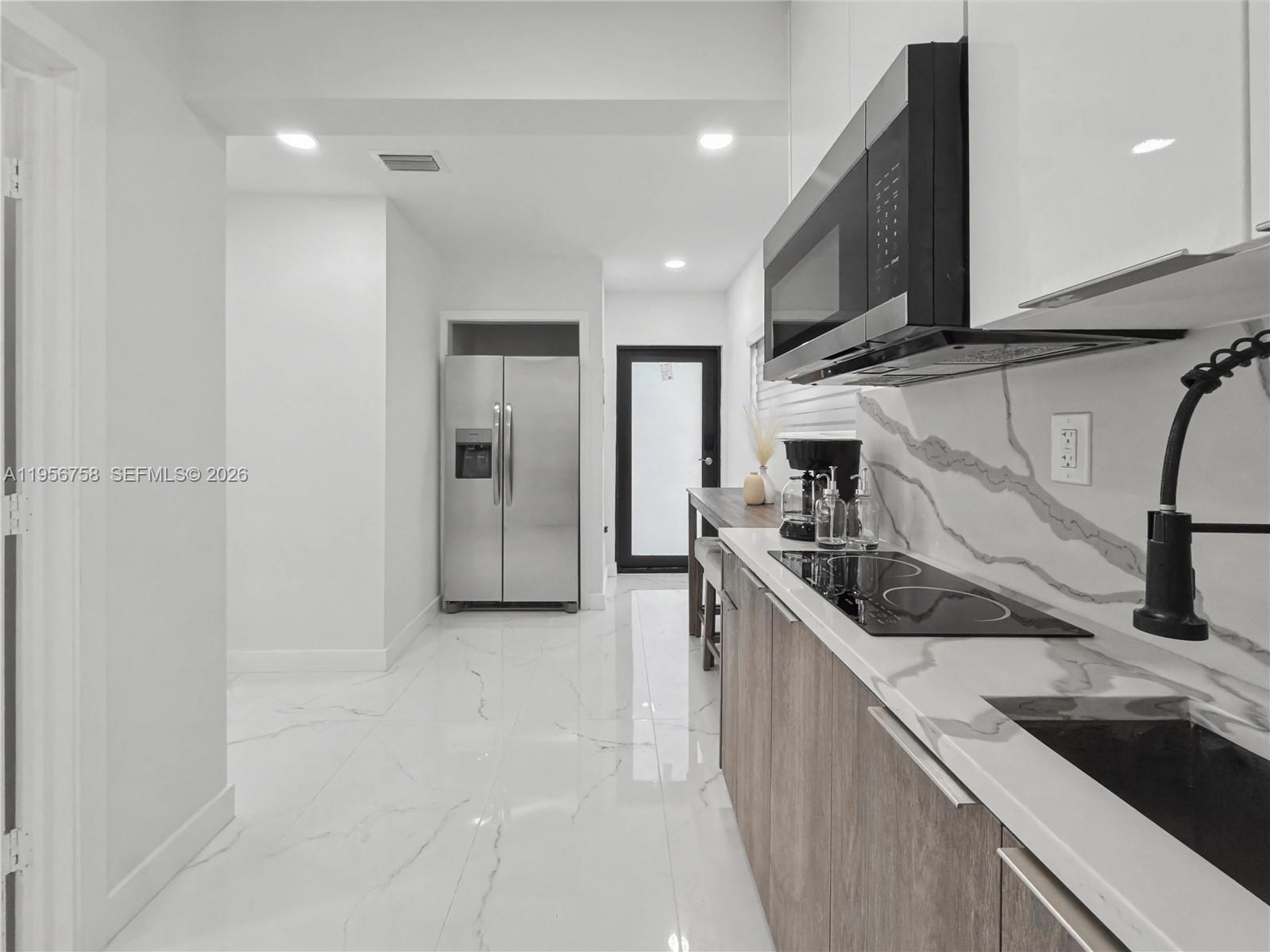 2490 Southwest 17th Street Miami, FL 33145 - Photo 26 of 36 a kitchen with stainless steel appliances granite countertop a sink and a stove