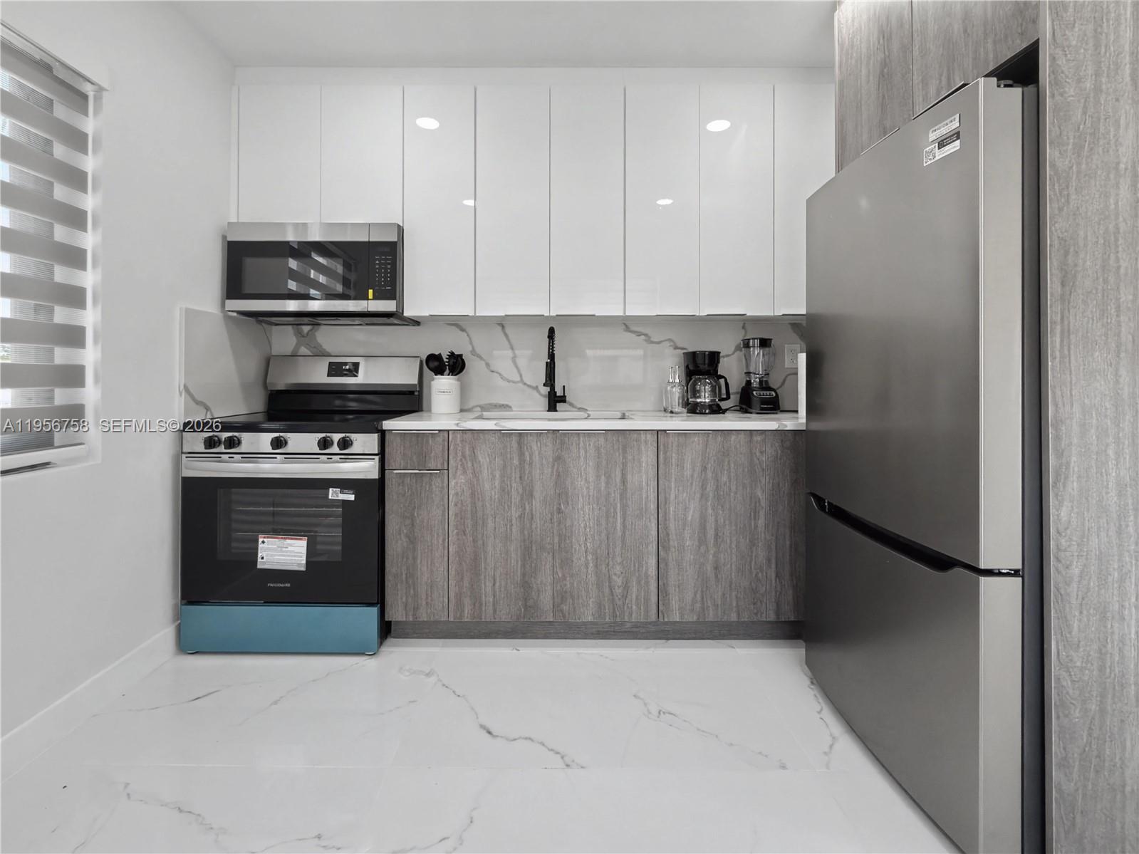 2490 Southwest 17th Street Miami, FL 33145 - Photo 33 of 36 a kitchen with stainless steel appliances granite countertop a refrigerator stove a sink and dishwasher