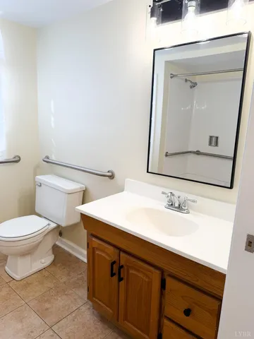 a bathroom with a toilet sink vanity and mirror