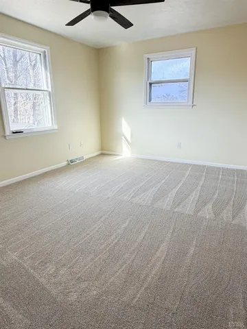 an empty room with windows and cabinet