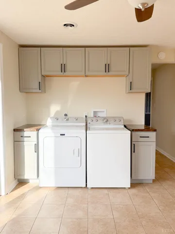 a utility room with cabinets washer and dryer