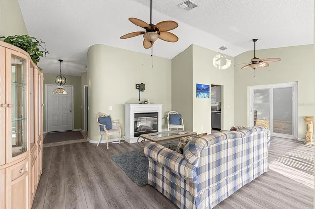 a dining room with wooden floor a chandelier a wooden table and chairs