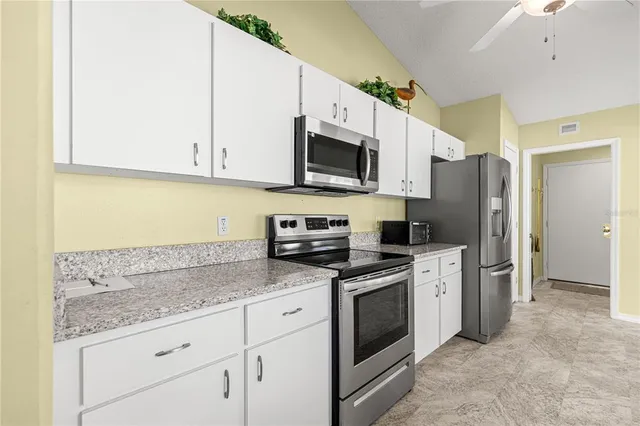 a room with a chandelier furniture and a kitchen view