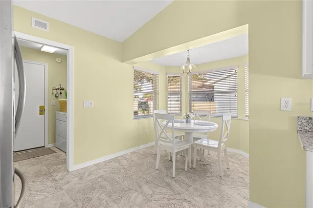 a kitchen with stainless steel appliances granite countertop a refrigerator a stove a sink a oven with a dining table and chairs