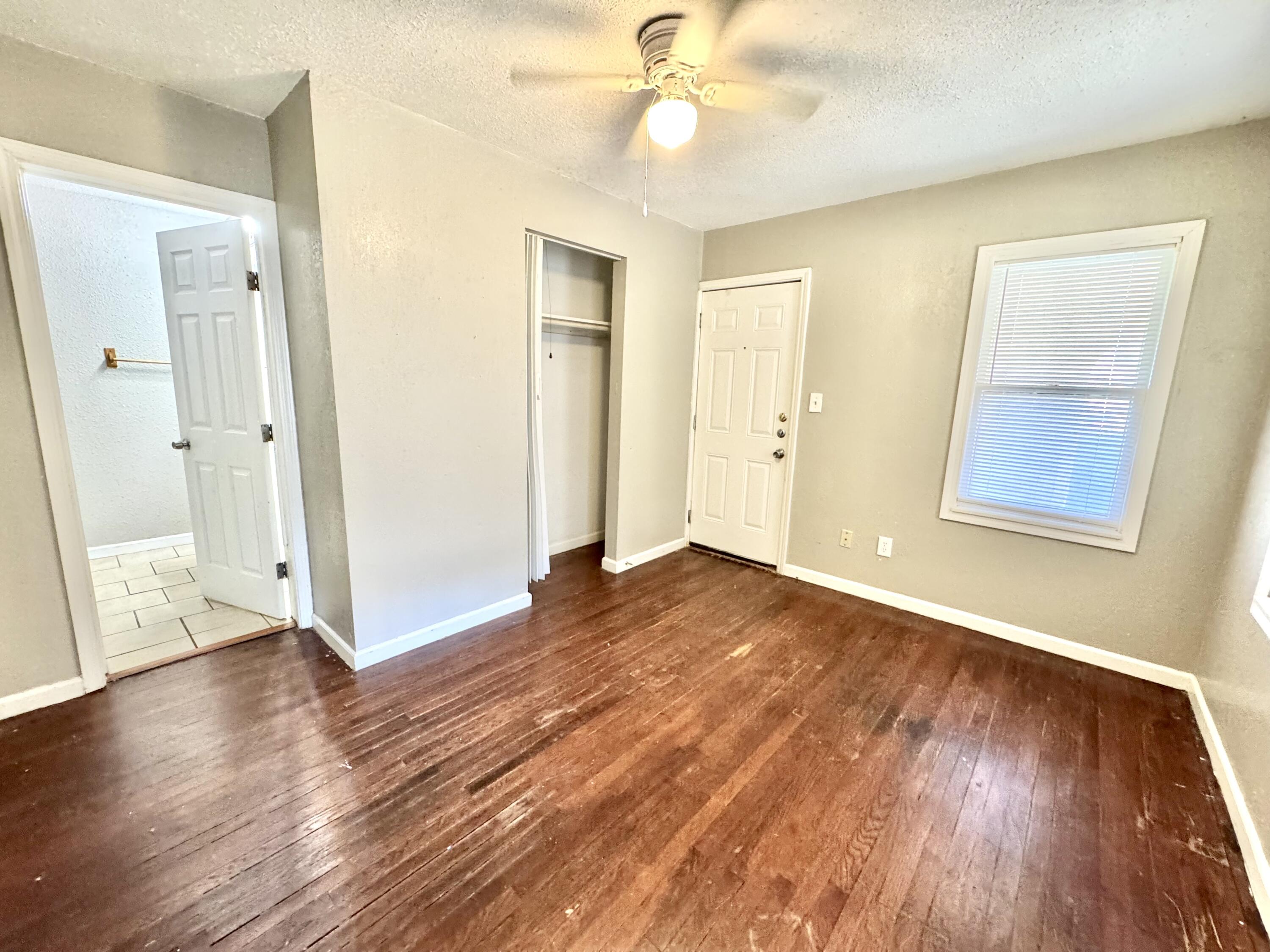 2421 22nd Street, Unit FRONT Lubbock, TX 79411 - Photo 12 of 17 a view of an empty room with wooden floor and a window