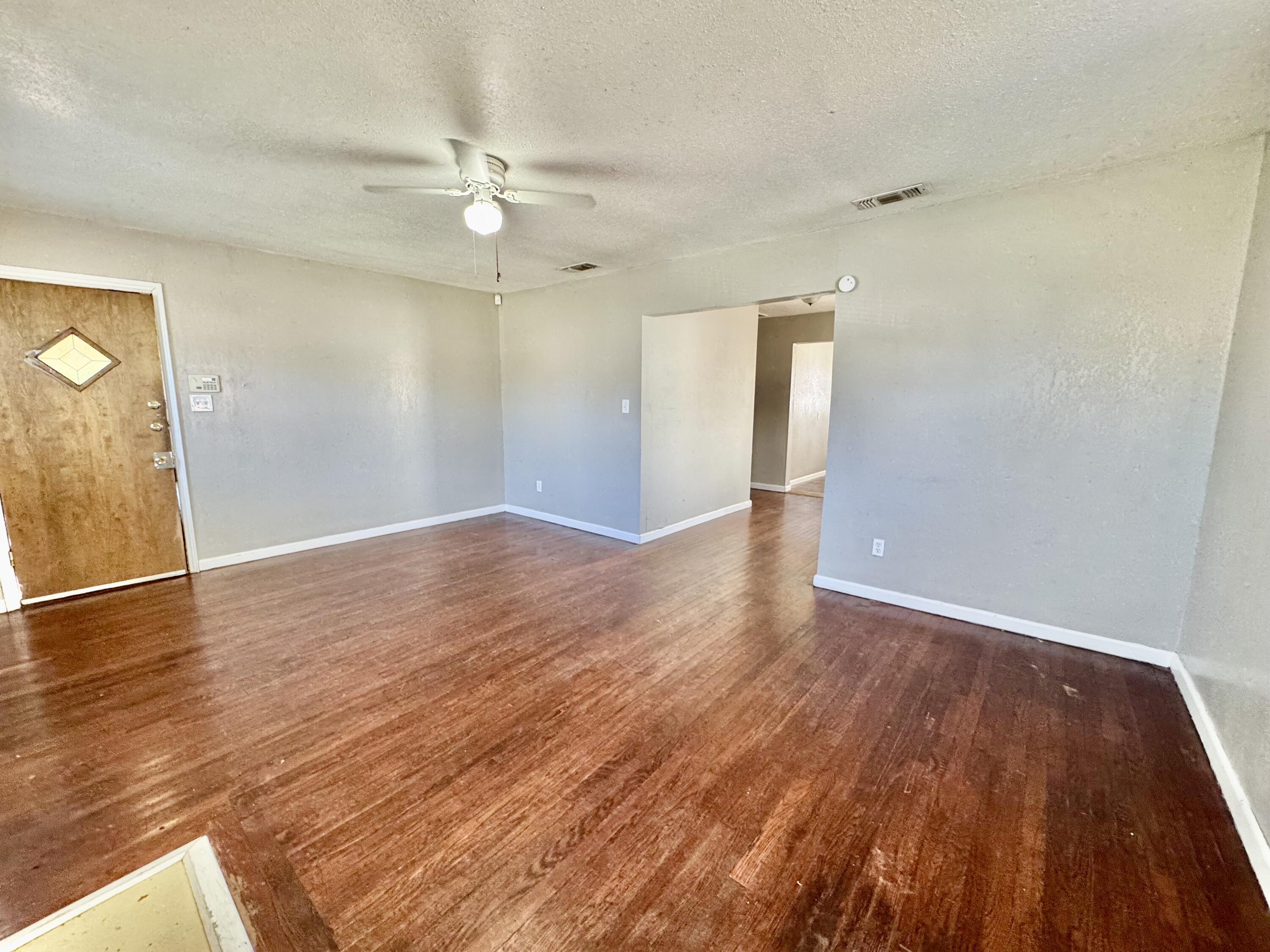 2421 22nd Street, Unit FRONT Lubbock, TX 79411 - Photo 5 of 17 an empty room with wooden floor and windows
