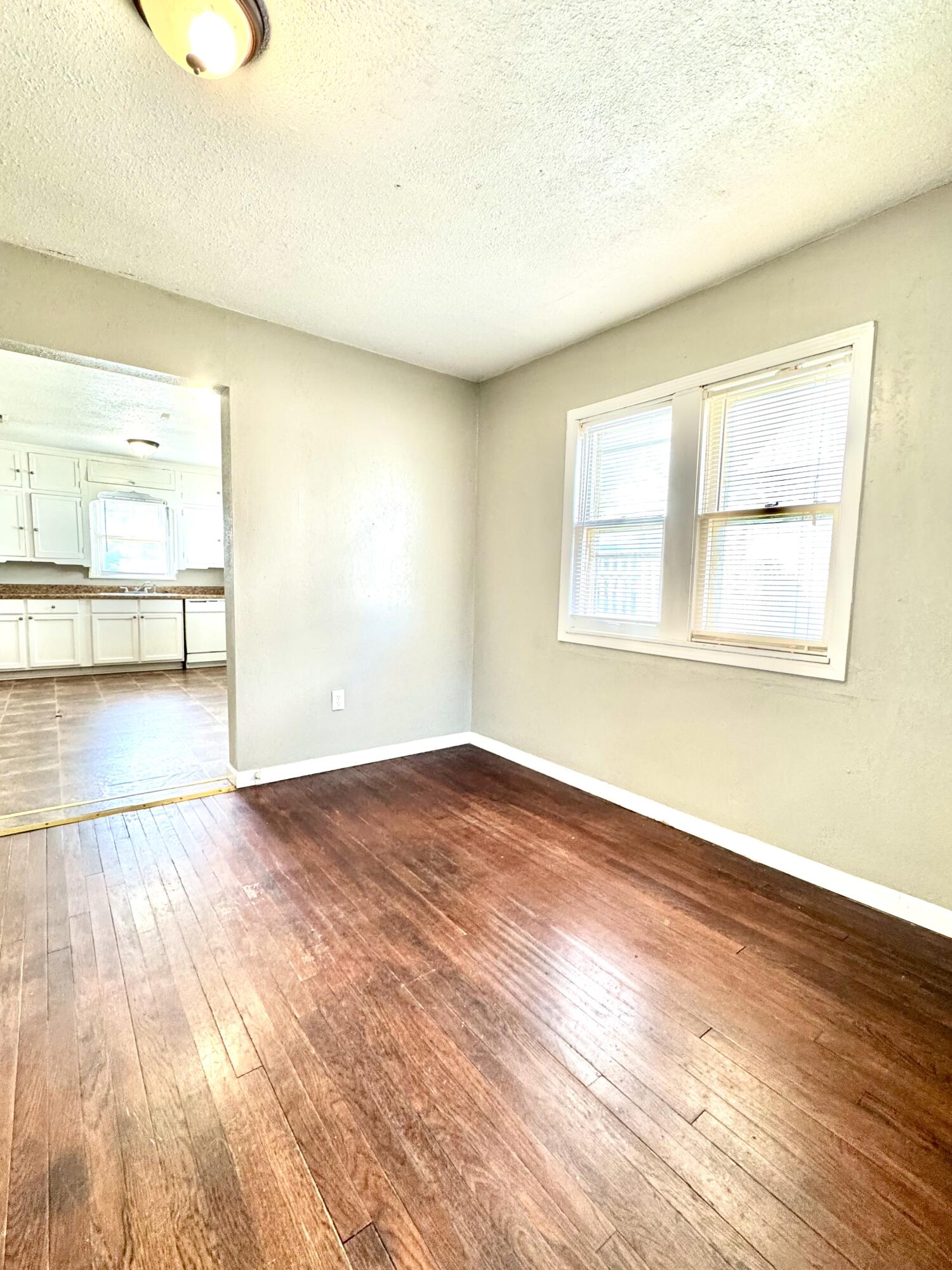 2421 22nd Street, Unit FRONT Lubbock, TX 79411 - Photo 6 of 17 an empty room with wooden floor and windows