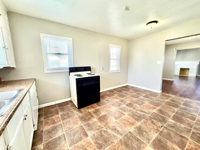 a view of a kitchen with wooden cabinet and a window