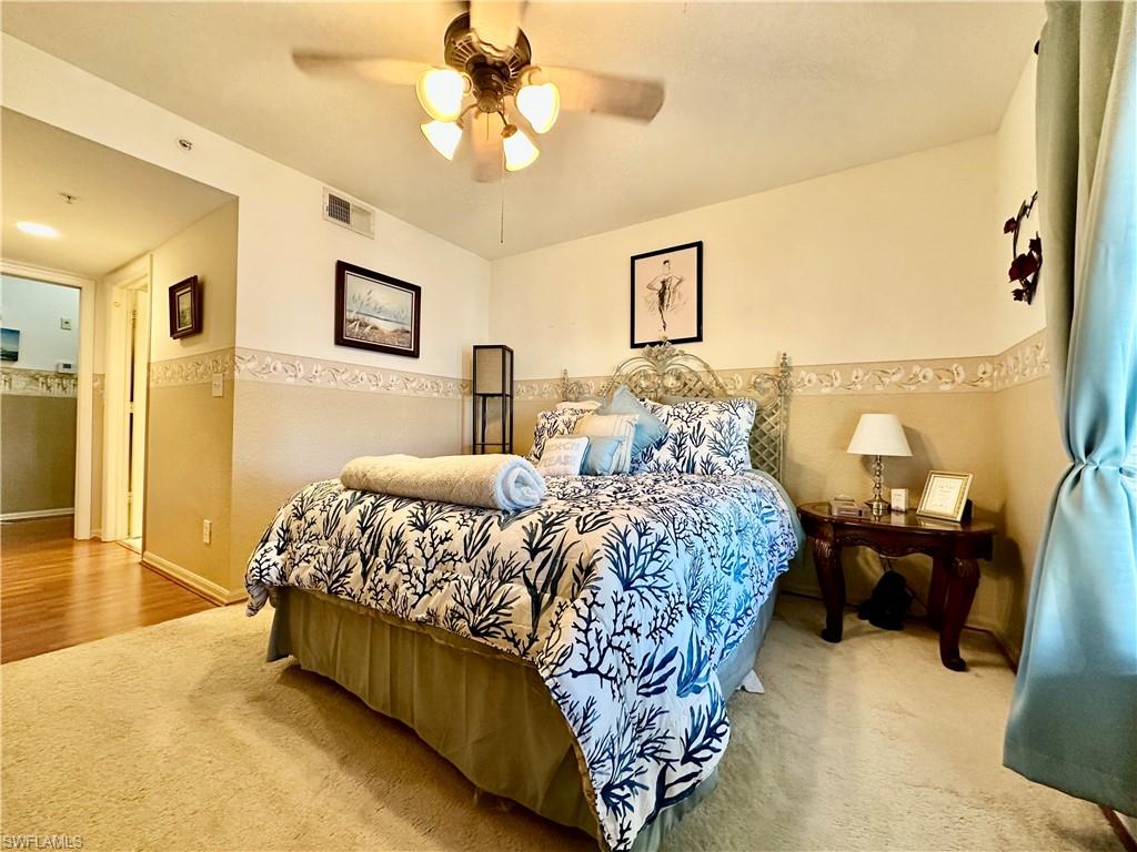 4700 St Croix Lane, Unit 335 Naples, FL 34109 - Photo 10 of 31 a bed sitting in a spacious bedroom next to a window and a flat screen tv