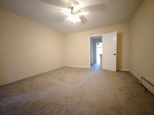an empty room with closet and a chandelier fan