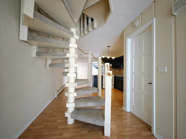 a view of a hallway with wooden floor and entryway