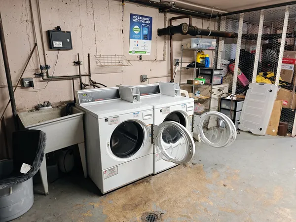 a utility room with dryer washer and a view of living room