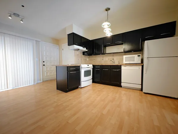 a kitchen with stainless steel appliances a refrigerator and a stove top oven