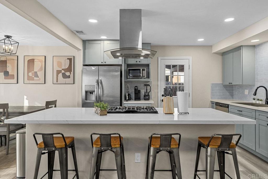 a kitchen with stainless steel appliances kitchen island a table and chairs