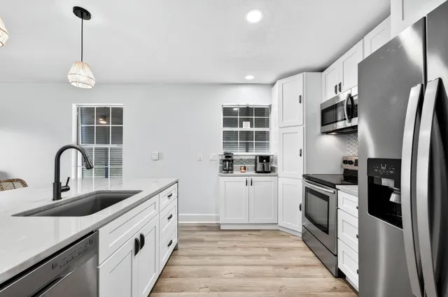 a kitchen with cabinets wooden floor and a window