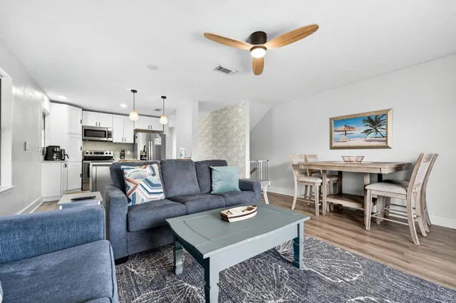 a living room with furniture and kitchen view
