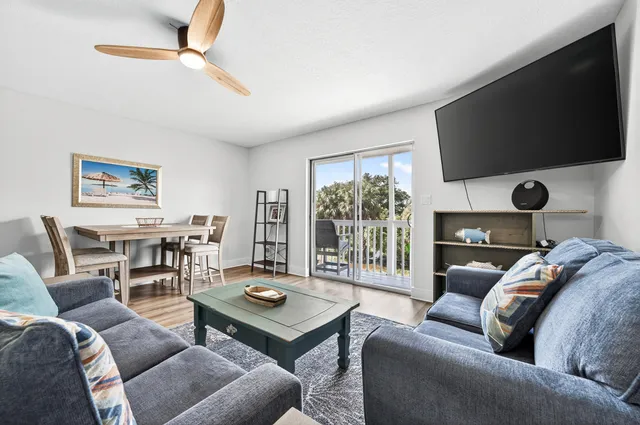 a living room with furniture a flat screen tv and a large window