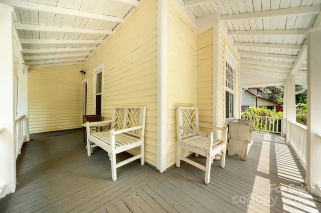 a view of a balcony with chairs and wooden floor